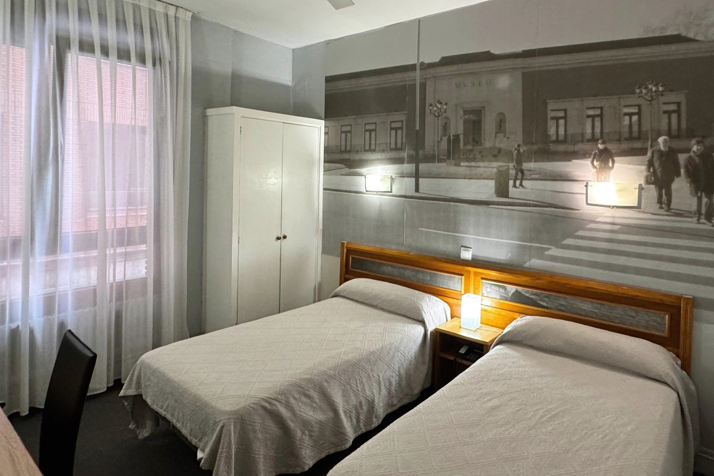 Habitación doble con dos camas individuales y decoración urbana en el Hotel Photo Zabalburu de Bilbao