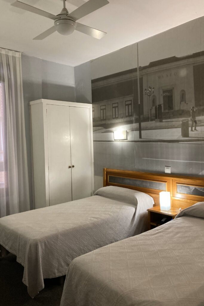 Habitación doble twin con dos camas individuales, armario blanco y mural fotográfico en el Hotel Photo Zabalburu de Bilbao